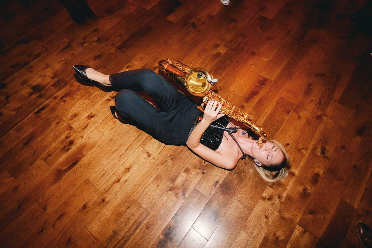 Amy Cyr playing saxophone from the dance floor, caught mid-performance